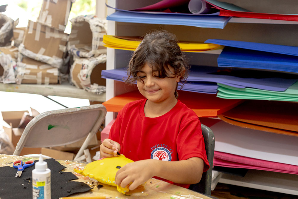 Elementary girl enjoying afterschool craft class