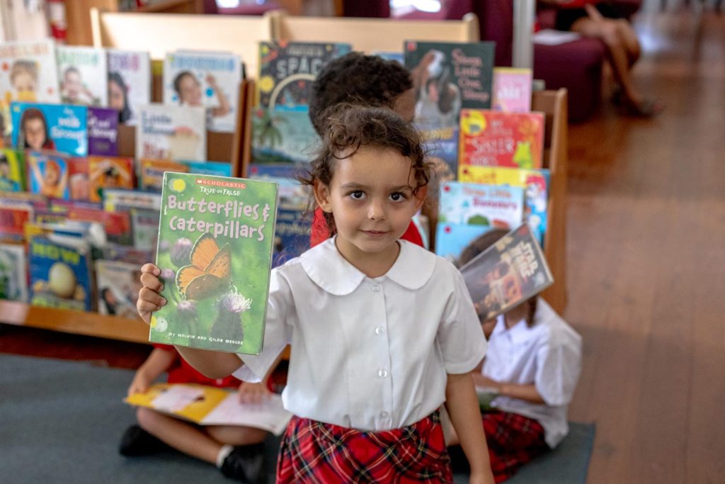 Elementary pupil holding up her favourite book