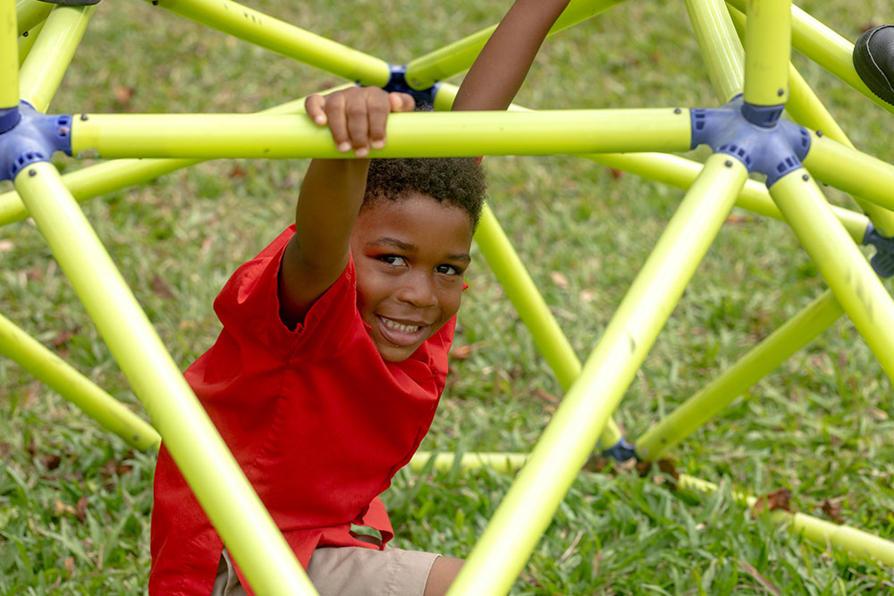 Smiling junior pupil in climbing frame