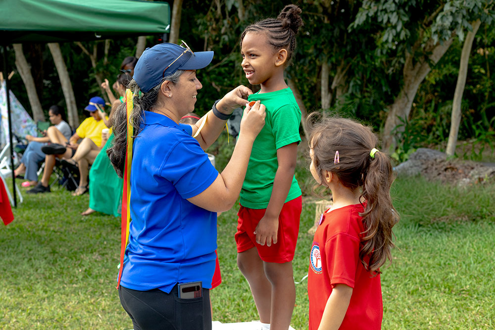 Teacher pinning an award to a pupil